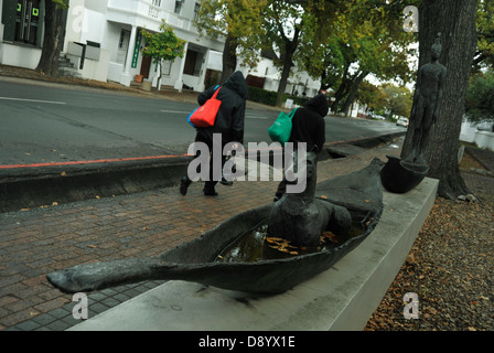 Scena di due donne pedoni camminare passato arte di strada in un giorno di pioggia in Dorp street Stellenbosch South Africa Vacanze viaggi Foto Stock