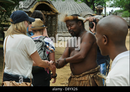 Persone, adulto Zulu uomo, abito tradizionale, saluto donna turistica, illustrazione, Villaggio a tema Shakaland, KwaZulu-Nata, Sudafrica, etnico, cultura Foto Stock