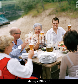 Popolo sorridente di bere birra durante la festa di mezza estate, Svezia. Foto Stock