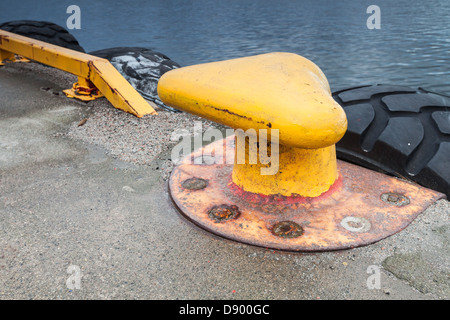 Giallo bollard ormeggio sul molo di cemento Foto Stock