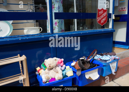 Un orsacchiotto di peluche e altri articoli per la vendita nelle caselle al di fuori di un esercito della salvezza la carità shop. Foto Stock