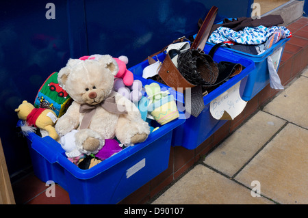 Un orsacchiotto di peluche e altri articoli per la vendita nelle caselle al di fuori di un esercito della salvezza la carità shop. Foto Stock