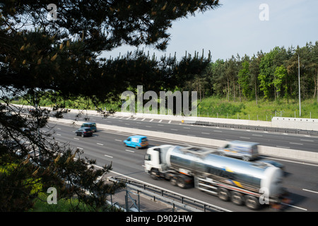 Veicoli per il trasporto merci e le automobili viaggiano lungo l'autostrada M25, attraverso Essex, UK. Foto Stock
