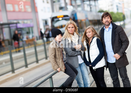 Famiglia con due bambini in attesa di tram Foto Stock