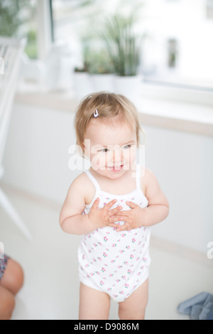 Poco ragazza sorridente in ambienti interni Foto Stock