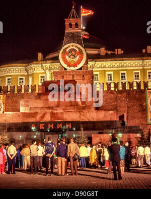 1 maggio 1987 - Mosca, RU - illuminata di notte in onore del giorno di maggio, Moscoviti e turisti nella Piazza Rossa si riuniscono di fronte al mausoleo di Lenin per guardare la modifica oraria di 24 ore di guardia d'onore. Al di sopra del mausoleo sorge la torre del Senato adornata con la circolare emblema dello stato dell'Unione Sovietica. Dietro la torre, il vecchio edificio del Senato dietro le mura del Cremlino ha il martello e la falce banner rosso bandiera dell'URSS battenti dalla sua cupola. Il cambio della guardia, iniziato nel 1924 e interrotta solo durante la II Guerra Mondiale, è stata interrotta nel 1993 su ordini di poi il Presidente Boris Eltsin. Questo Foto Stock