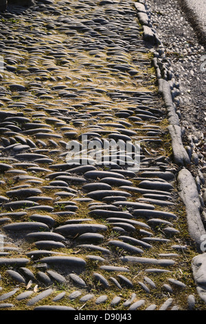 Pietre poste in lineari e modelli a spina di pesce per formare marciapiede e grondaia al di fuori di una terrazza di case, Llanrhystud, Wales, Regno Unito. Foto Stock