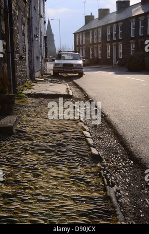 Pietre poste in lineari e modelli a spina di pesce per formare marciapiede e grondaia al di fuori di una terrazza di case, Llanrhystud, Wales, Regno Unito. Foto Stock