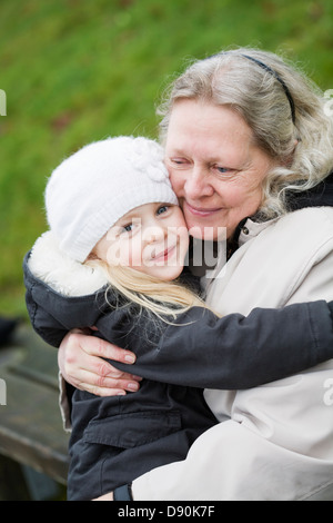 Ritratto di ragazza abbracciando la nonna Foto Stock