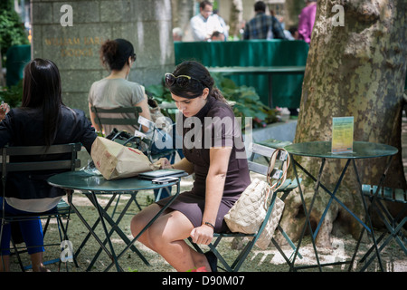 Un visitatore a Bryant Park di New York utilizza il suo Amazon Kindle ereader martedì 4 giugno, 2013. (© Richard B. Levine) Foto Stock