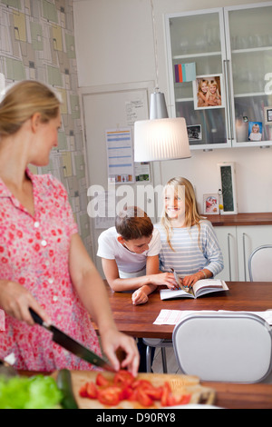 La madre ed i suoi figli in cucina Foto Stock