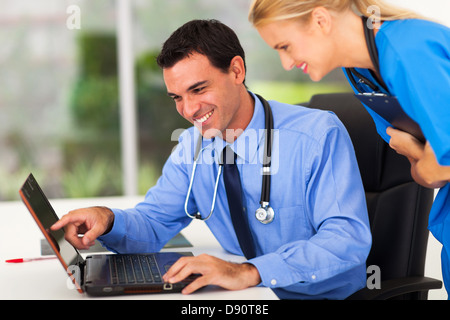 Felice medico maschio e un assistente medico guardare il computer Foto Stock