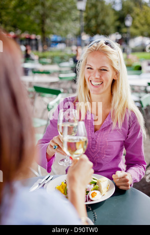 Due donne del vino di tostatura a outdoor cafe Foto Stock