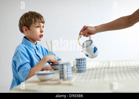 Ragazzo di mangiare con bacchette Foto Stock