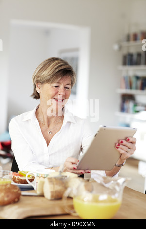 Donna matura con tavoletta digitale Foto Stock