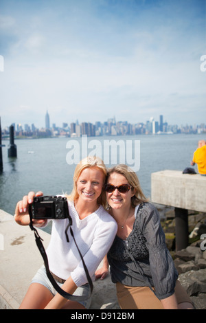 Madre e figlia di fotografare sé con skyline di New York in background Foto Stock