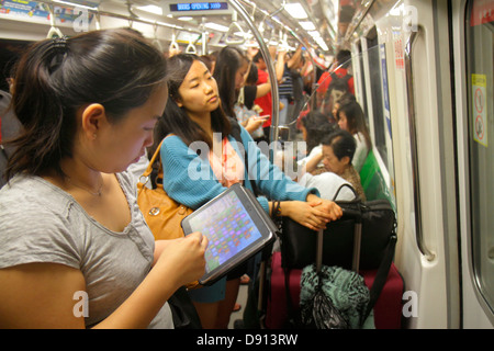 Singapore Lavender MRT Station, East West Line, treno della metropolitana, donne asiatiche, penduter, tablet, iPad Apple, in piedi, Sing130201041 Foto Stock