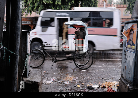 Un rickshaw driver durante una pioggia pesante. Jaipur, Rajasthan, India Foto Stock