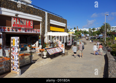 Beachfront negozi e bar di fronte alla spiaggia di Playa de Las Cucharas, Costa Teguise, Lanzarote, Isole Canarie Foto Stock
