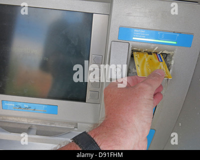 Inserire una carta conto nazionale in un bancomat cooperativo giallo Foto Stock