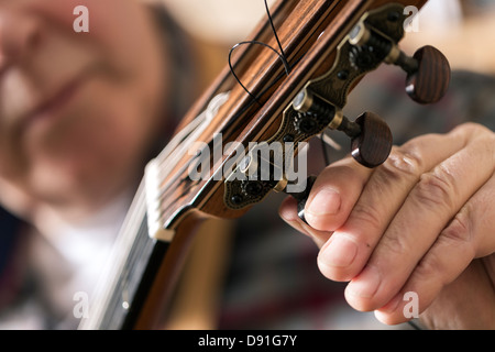 Chiusura del liutaio Tuning e prove di chitarra acustica in officina Foto Stock