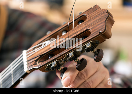 Chiusura del liutaio Tuning e prove di chitarra acustica in officina Foto Stock