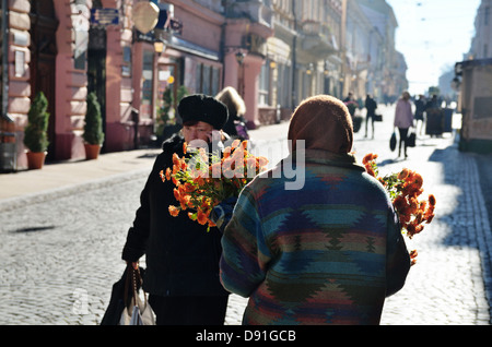 Una vecchia donna vende fiori su Olga Kobylianska Street in Chernivtsi, Ucraina - Ott 2012 Foto Stock