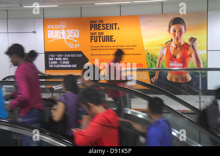 Singapore,Dhoby Ghaut MRT Station,North South Line,metropolitana treno,scala mobile,piloti,pendolari,cartellone,pubblicità,annuncio,pubblicità,pubblicità,pubblicità,pubblicità,pubblicità,pubblicità,pubblicità,pubblicità,pubblicità,pubblicità,donna asiatica fe Foto Stock