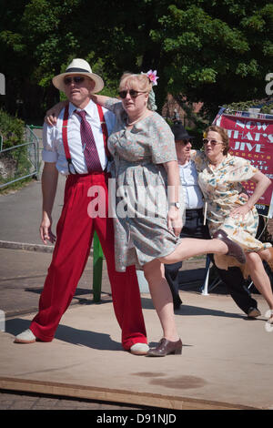 Hampshire, Inghilterra, Regno Unito. 8 Giugno 2013. Swing dance troupe 'ora che la Jive" sul palco durante la guerra sulla linea, una celebrazione di tutte le cose la II Guerra Mondiale sulla metà Hants ferroviaria linea di crescione in Hampshire. Rievocazione delle società vestito in periodo di abiti civili o militari completo regalia come musica, vita sulla home anteriore e i veicoli d'epoca sono celebrati con un certo numero di treni a vapore in movimento ai passeggeri di varie stazioni lungo la linea che hanno partecipato all'evento. Credito: Patricia Phillips/Alamy Live News Foto Stock