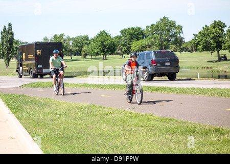 Un Caucasian padre e figlio di cavalcare le loro biciclette per fare esercizio e piacere sul lago Hefner sentieri nella città di Oklahoma, Oklahoma, Stati Uniti d'America. Foto Stock