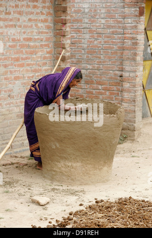 Donna che fa il vaso gigante nel suo cortile, Bangladesh Foto Stock