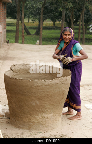 Donna che fa il vaso gigante nel suo cortile, Bangladesh Foto Stock