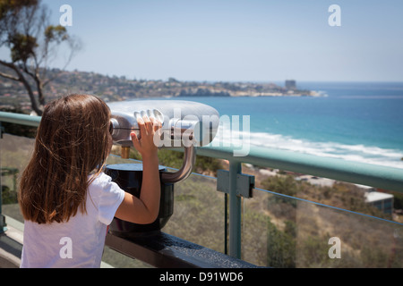 Ragazza giovane che guarda sull'Oceano Pacifico e La Jolla, California con telescopio. Foto Stock