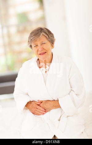 Senior donna sensazione di malessere a casa Foto Stock