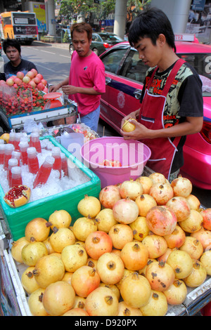 Thailandia,Thai,Bangkok,Silom,Silom Road,strada,venditori ambulanti,bancarelle stand mercato,melograno,succhi di frutta,bevande,cibo,uomo asiatico maschio,j Foto Stock