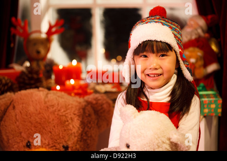 Una ragazza felice e toy nel suo handGirl con regalo di Natale Foto Stock