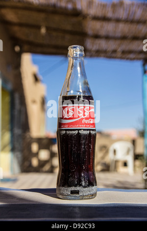 Una bottiglia di Coca Cola scritta in arabo in una città desertica di Merzouga, Marocco. Foto Stock