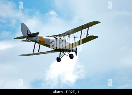 Tiger Moth in volo contro il bianco delle nuvole e cielo blu Foto Stock