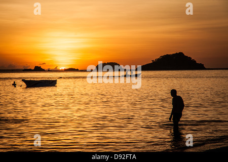 Tramonto dietro un nuotatore sulla spiaggia Bounty Foto Stock