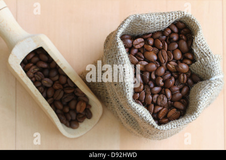 I chicchi di caffè nel sacco di iuta e sulla paletta di legno Foto Stock