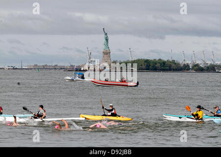 La città di NEW YORK, Stati Uniti d'America. 8 Giugno, 2013. Nuotatori passano per la Statua della Libertà durante la Manhattan Island Marathon swim. Credito: Trevor Collens/Alamy Live News Foto Stock