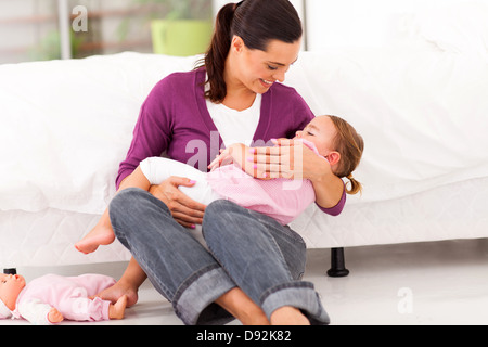 Madre premurosa dondolo bambino la sua ragazza a dormire Foto Stock