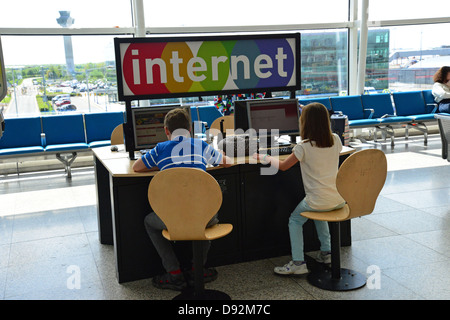 I bambini presso un chiosco internet nel terminal di partenza, l'aeroporto di Stansted, Stansted Mountfitchet, Essex, Inghilterra, Regno Unito Foto Stock
