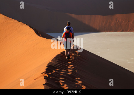 Famiglia di arrampicata duna di sabbia accanto a Deadvlei, vicino al Sossusvlei, Namib-Naukluft National Park, Namibia, Africa Foto Stock