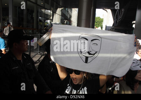 Bangkok , Thailandia. Il 9 giugno 2013. Un manifestante holding Guy Falkes maschera bianca poster durante il rally . I manifestanti che indossano "Guy Fawkes' continuare al rally di Bangkok e di altri parti della Tailandia contro la Yingluck Shinawatra di governo che dicono gli avversari è un "puppet' regime controllato da fuggitivo ex Premier Thaksin Shinawatra. Credito: John Vincent/Alamy Live News Foto Stock