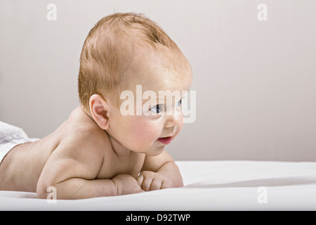 Studio shot del neonato sdraiato sul letto Foto Stock