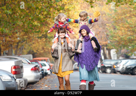 Due mamme con le loro figlie sulle loro spalle in Prenzlauer Berg di Berlino, Germania Foto Stock