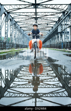 Ragazzo di equitazione Bicicletta attraverso ponte in Repubblica Ceca Foto Stock