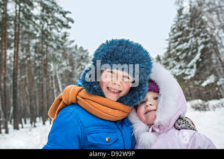 Un allegro fratello e sorella in caldo abbigliamento invernale all'aperto in inverno Foto Stock