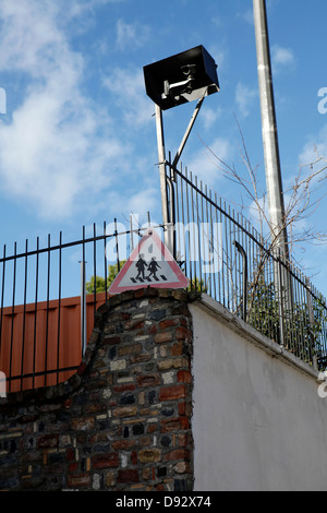 Basso angolo di visione di un video sorveglianza telecamera attaccata a una recinzione Foto Stock